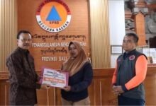 Sekretaris Daerah (Sekda) Provinsi Bali, Dewa Made Indra, menyerahkan santunan kepada ahli waris korban banjir yang melanda beberapa wilayah di Bali pada Jumat (19/9/2025) di Kantor BPBD Provinsi Bali, Renon, Denpasar. (dok.istimewa)