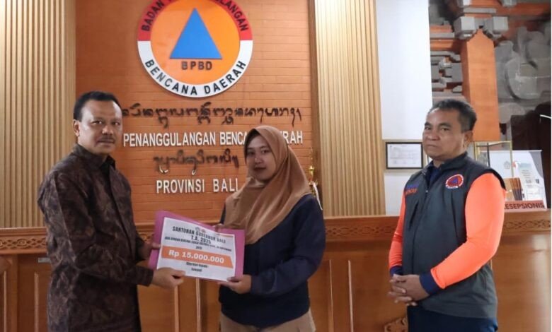 Sekretaris Daerah (Sekda) Provinsi Bali, Dewa Made Indra, menyerahkan santunan kepada ahli waris korban banjir yang melanda beberapa wilayah di Bali pada Jumat (19/9/2025) di Kantor BPBD Provinsi Bali, Renon, Denpasar. (dok.istimewa)