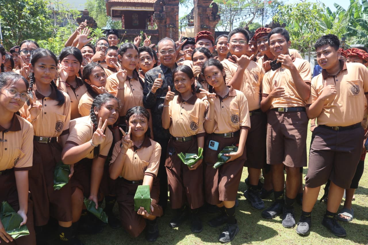 Gubernur Bali Wayan Koster saat mengabadikan momen bersama siswa siswi SMPN 13 Denpasar pada Jumat (18/9/2026). (dok: istimewa)