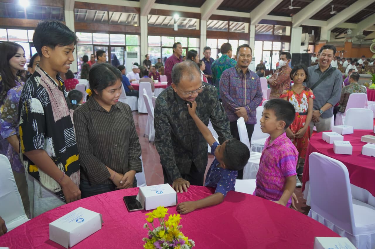 Gubernur Bali Wayan Koster saat menyapa anak anak dalam kegiatan penyerahan dokumen kependudukan yang difasilitasi Kejaksaan Tinggi Bali di Gedung Nari Graha, Denpasar pada Jumat (18/9/2026). (dok: istimewa)